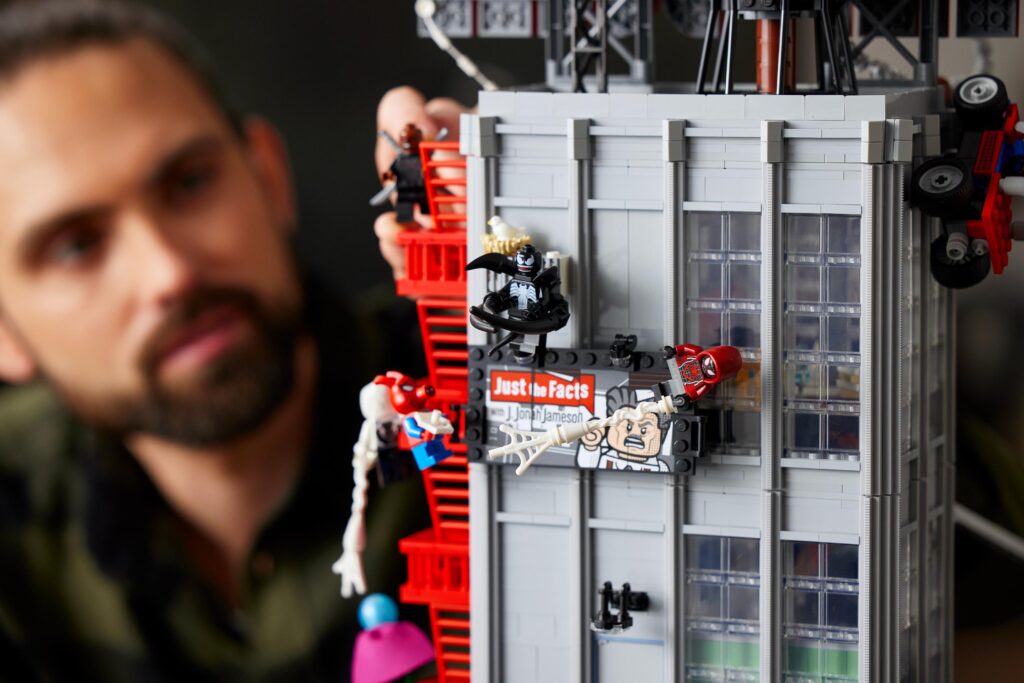 Hombre armando un set de lego marvel con Spider Man