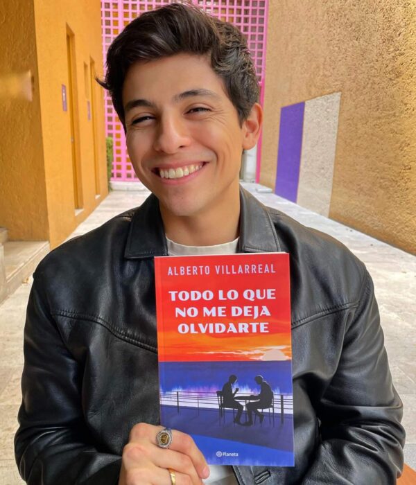 Alberto Villarreal sostiene su libro mientras sonrie