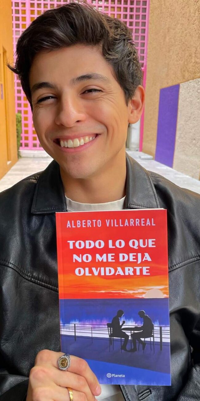 Alberto Villarreal sostiene su libro mientras sonrie
